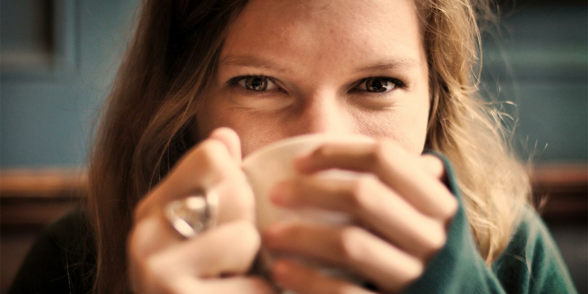 Homepage Seelsorge für Hörbehinderte - Frau trinkt Kaffe und schaut in die Kamera